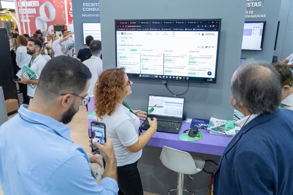 Karine apresenta visus workflow para visitantes do estande altoqi na feicon 2024