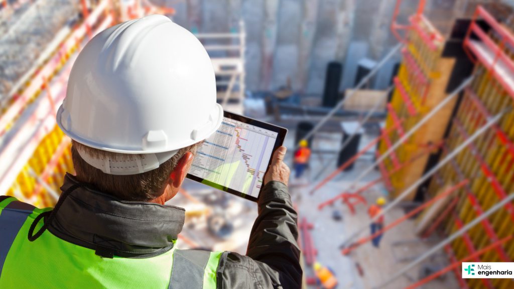 homem com capacete analisando grafico em tablet em uma obra