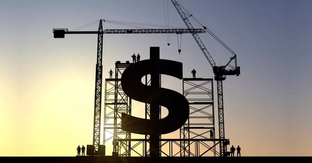 É a silhueta de uma construção ao nascer do sol. O destaque é uma estrutura grande em forma de dólar ($) apoiada por andaimes