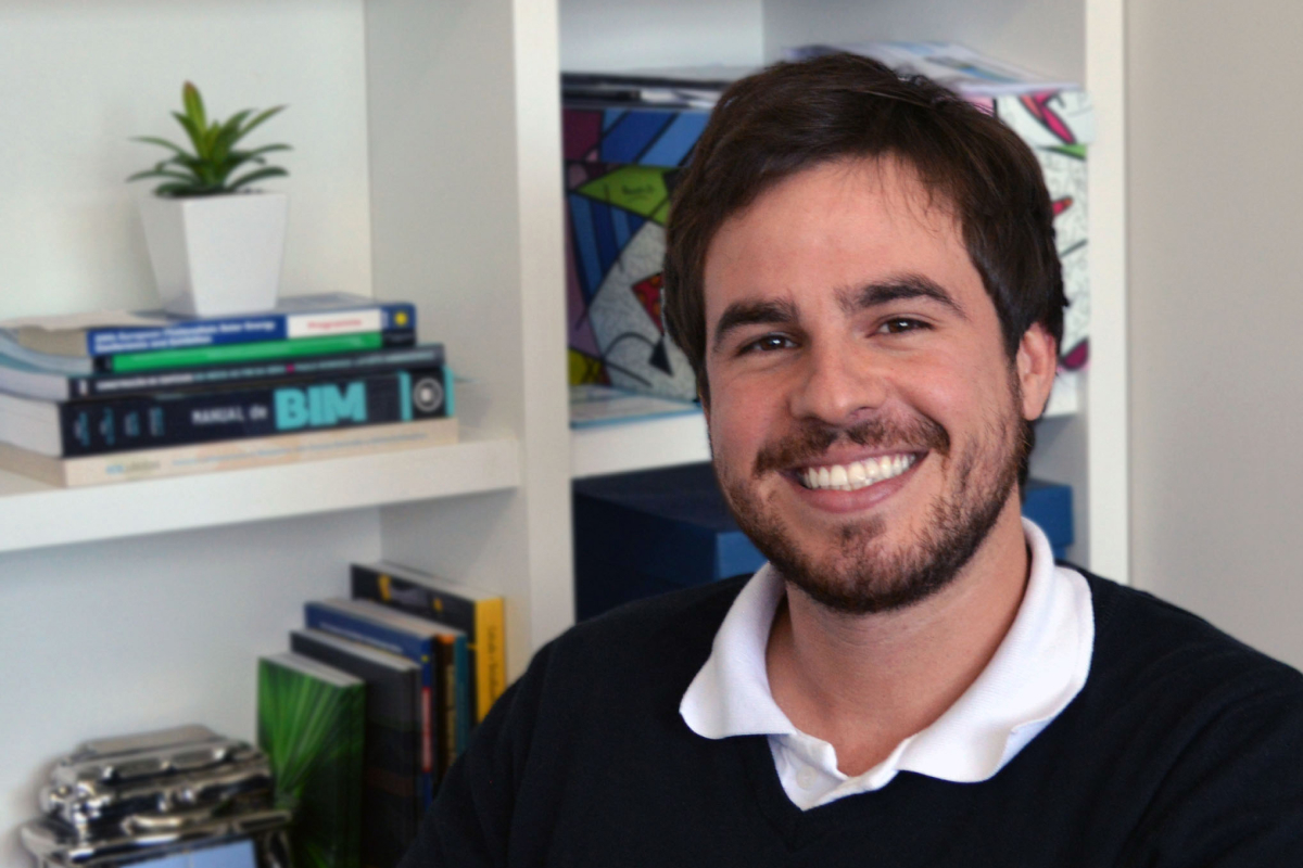 Andrigo Antoniolli, diretor-presidente da WAZ Engenharia, sorrindo para a foto e atrás dele tem uma estante com livros